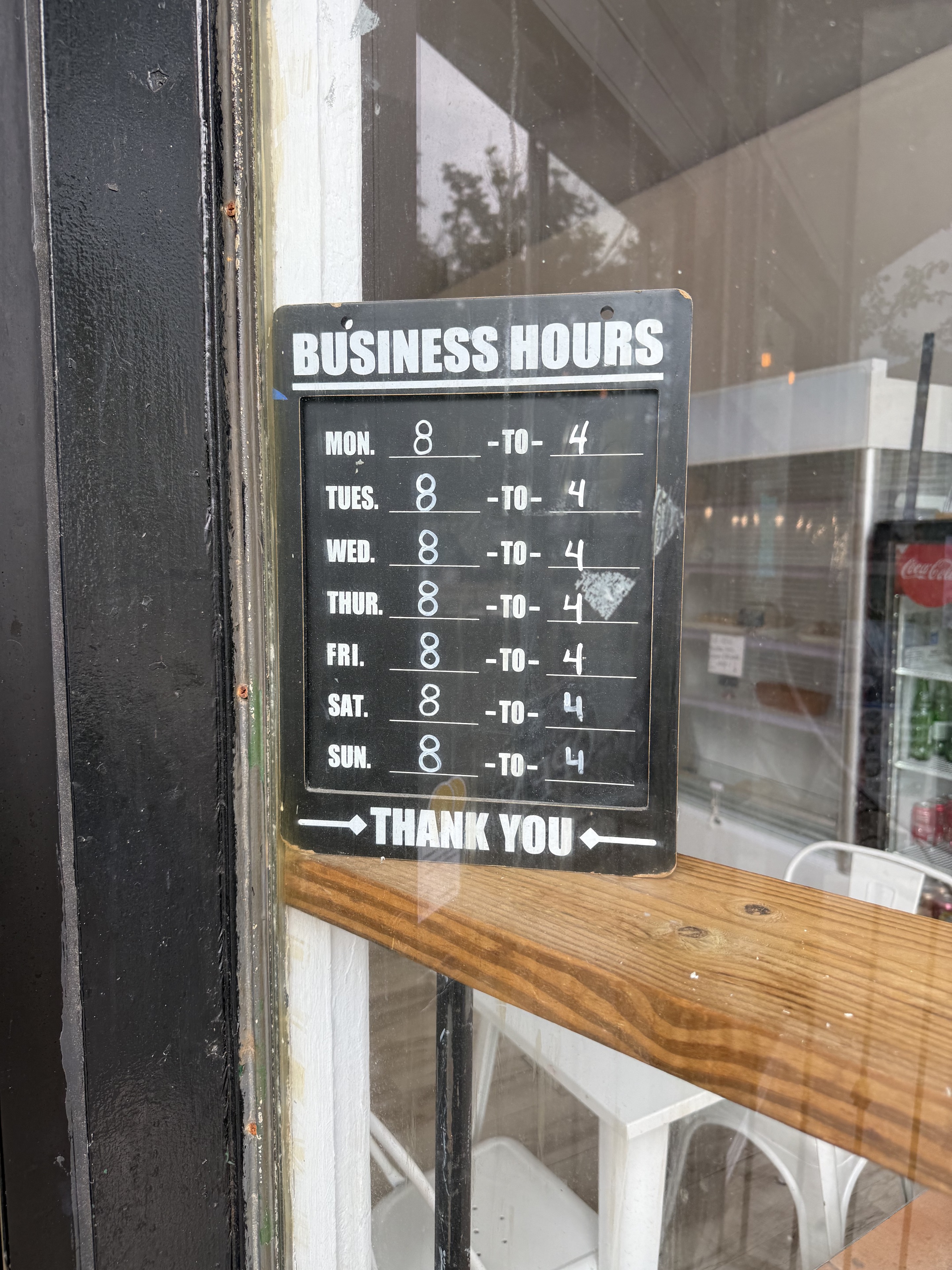 A photographed business-hours sign. Confirm current hours directly before visiting.